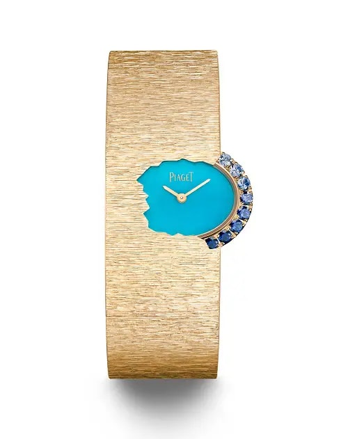 A golden watch with oval dial half-hidden, encrusted with blue gemstones
