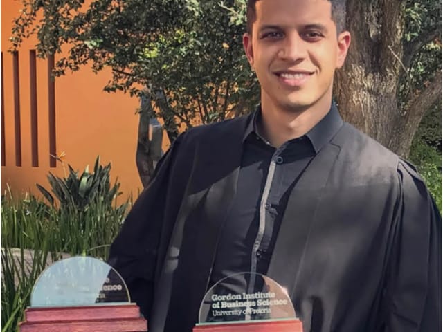 A portrait of Karmlin Naidoo with an award