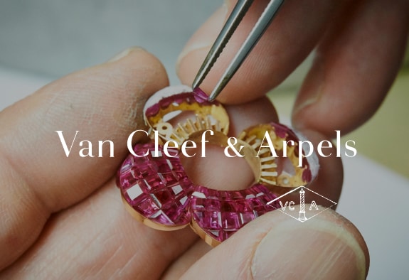 Van Cleef & Arpels logo with a person assembling a jewellery piece in the background