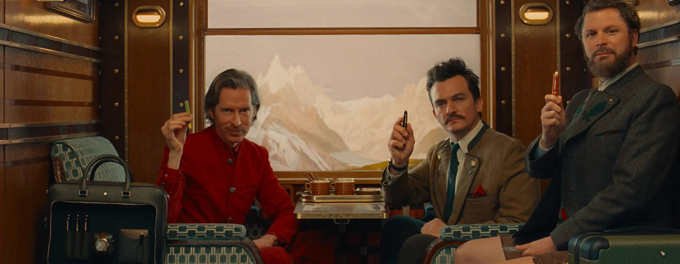 Three men sitting in the vintage train with iconic Montblanc pens