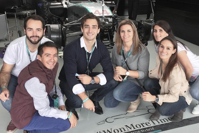 A photo of a group of people in front of F1 car